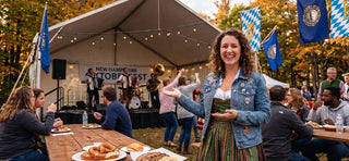 Woman in a traditional dirndl enjoying one of the best Oktoberfest events in New Hampshire with live German music, bratwurst, pretzels, and festival crowds.