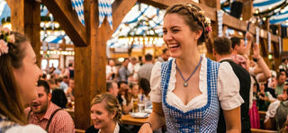 Woman in a traditional dirndl enjoying the festive atmosphere inside an Oktoberfest beer tent.