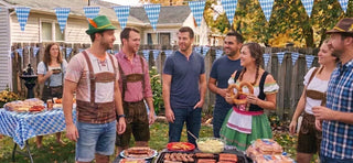Group of friends hosting an Oktoberfest party at home wearing lederhosen and dirndl attire, grilling German sausages, serving pretzels, and recreating the fun atmosphere of Munich Oktoberfest.