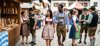 Foreign visitors wearing traditional Lederhosen and Dirndl while exploring a Bavarian cultural festival market.