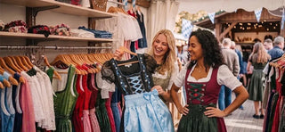Women shopping for traditional Oktoberfest dirndl dresses at a Bavarian clothing store, comparing styles and colors to find the perfect dirndl for Oktoberfest celebrations.
