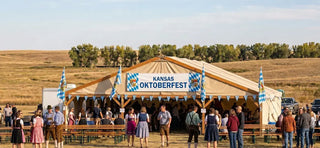 Kansas Oktoberfest festival featuring a traditional beer tent, Bavarian flags, and festivalgoers.