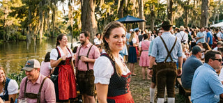 Outdoor Oktoberfest celebration in Louisiana with guests dressed in dirndls and lederhosen.